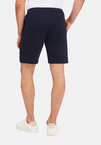Marineblauwe shorts van een katoenmix, met een aansluitende stijl, elastische tailleband en zijzakken. Gladde textuur met minimale details.