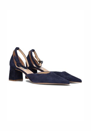 Chaussures à talon bloc en daim bleu marine avec un bout pointu, une bride au niveau de la cheville avec un détail en boucle, et une semelle intérieure rembourrée pour le confort.
