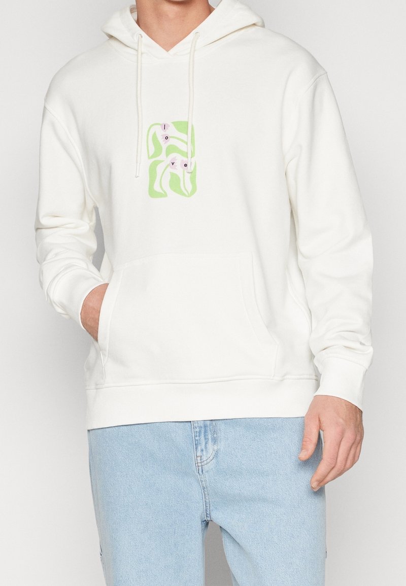 Sweat à capuche blanc avec une poche avant, présentant un motif graphique coloré de lettres et de formes. Fabriqué en tissu doux avec une capuche à cordon.