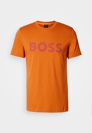 Orange cotton t-shirt with short sleeves, features a prominent purple "BOSS" logo across the chest, round neckline, smooth texture.