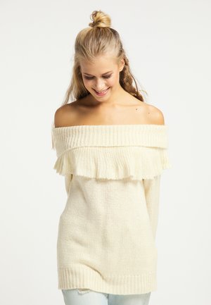 Off-shoulder creme strikkegenser med ruffle-detaljer ved halsudskæringen og ribbede manchetter, der har en løs, afslappet pasform og tekstureret stof.