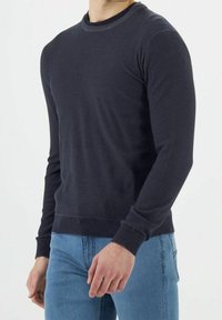 Dunkel marineblauer Sweatshirt mit Rundhalsausschnitt aus weichem Stoff, ausgestattet mit langen Ärmeln sowie gerippten Bündchen und Saum für eine körpernahe Passform.