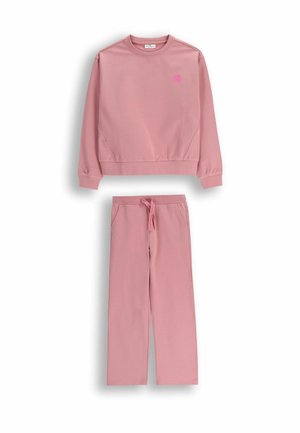 Różowa bluza i dopasowane spodnie wykonane z miękkiego materiału. Bluza ma okrągły dekolt i ściągacze; spodnie mają kieszenie i regulowany pas.