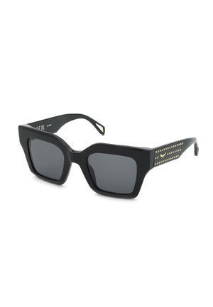 Gafas de sol cuadradas negras de gran tamaño con lentes oscuras y detalles de tachuelas doradas en las patillas gruesas sobre un fondo blanco.