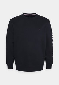 Schwarzes Sweatshirt mit Rundhalsausschnitt, langen Ärmeln, gerippten Bündchen und Saum. Verfügt über ein kleines Logo auf der Brust und einen Schriftzug entlang des linken Ärmels.