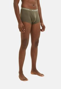 Olive green boxer shorts with a snug fit, elastic waistband featuring 'TOM TAILOR' logo, smooth texture, and mid-thigh length.