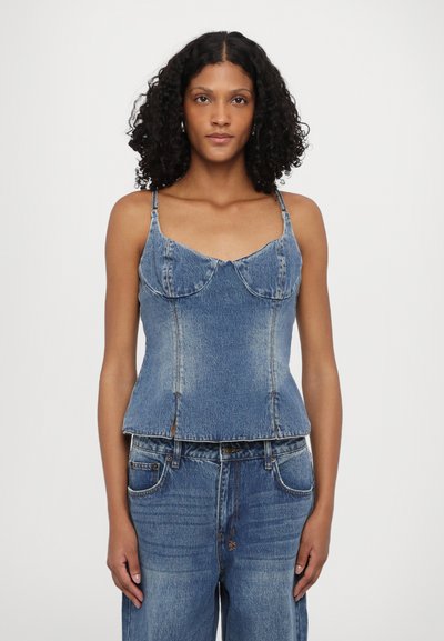 Top din denim de culoare albastru deschis, cu cusături conturate, bretele ajustabile și fante laterale la tiv pentru o ajustare elegantă. Textura pare ușor decolorată.