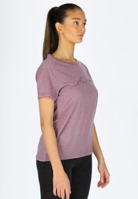 Maglietta corta viola melangiata con maniche corte, scollatura rotonda e una sottile grafica di montagne sul petto. Abbinata a leggings neri.