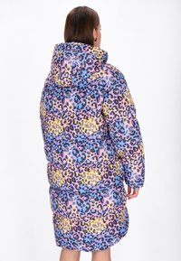 Piepildīta parka pasteļkrāsās ar leopardu rakstu, ar kapuci un vidēju garumu, ar kviltotu tekstūru.