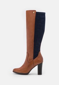 Brown leather and navy suede knee-high boot with a rounded toe, stacked heel, and decorative stitching on the shaft. Gold hardware detail present.