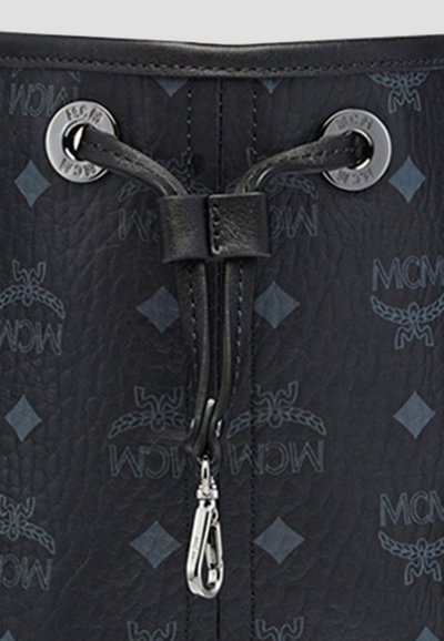 Schwarzes strukturiertes Leder mit blauen Rauten und MCM-Logos, ausgestattet mit einem schwarzen Kordelzug, der durch silberne Ösen gefädelt ist, und einem silbernen Verschluss in der Mitte.
