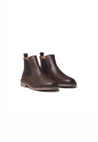 Botas de cuero marrón hasta el tobillo con paneles laterales elásticos, punta redondeada y un acabado texturizado; detalles de costura a lo largo de la suela.