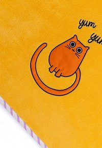 Illustration einer orangefarbenen Katze auf einer weichen, gelben Decke, mit einem geschwungenen Schwanz und großen Augen. Gestreifter Rand in Pink und Weiß am Rand.