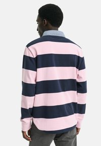 Polo a maniche lunghe con righe orizzontali rosa e navy, realizzato in cotone e con una texture morbida, dotato di un colletto in denim.