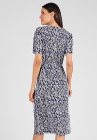 Vestido floral azul con un busto ajustado, mangas cortas y falda a la rodilla. Presenta un estampado multicolor en una tela ligera.