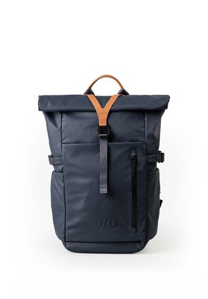 Dunkelblauer Rolltop-Rucksack mit beige-braunem Ledergriff, Front-Reißverschlusstasche und schwarzem Riemenverschluss auf weißem Hintergrund.