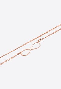 Collana infinita in oro rosa con catena delicata e pendente liscio e lucido. Il design presenta una forma a loop continuo, minimalista.