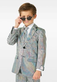 Iridescent ruuduline ülikond, millel on läikiv neljakandiline muster mitmetes värvustes. Koos valge ülikonna särgi ja sellele vastava lipsuga; mustad päikeseprillid.