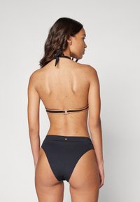 Black bikini set featuring a halter neck top with a tie and removable padding, complemented by high-waisted bottoms with a subtle logo detail.