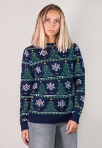 Knit sweater with a navy background, featuring green Christmas trees, white snowflakes, and colorful dots in a repeated pattern.