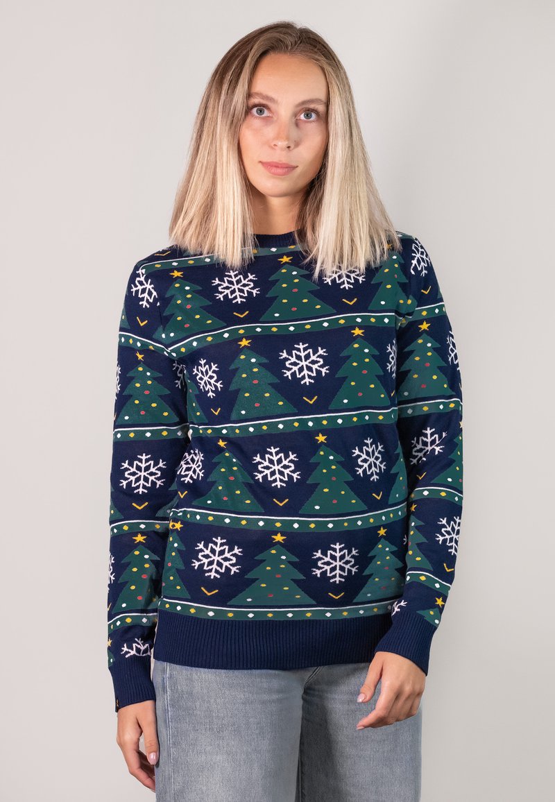 Knit sweater with a navy background, featuring green Christmas trees, white snowflakes, and colorful dots in a repeated pattern.