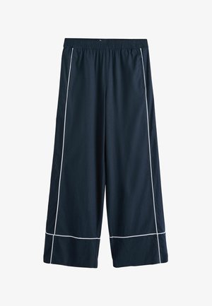 Pantalon large bleu marine avec surpiqûres blanches le long des coutures, taille élastique et poches latérales, présenté sur un fond blanc.