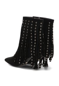 Botas de tobillo de ante negro con punta afilada, que presentan detalles de flecos y acentos de ojales plateados. Cremallera lateral para facilitar el uso.