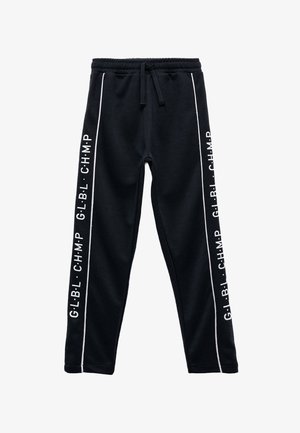 Zwarte sweatpants van zacht materiaal, met een trekkoord in de taille, witte zijkanten en bedrukte tekst op de buitenste naden.