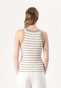 Rutet tanktop i hvit og lysebrun. Fitted design med ribbet tekstur og kontrasterende kant. Hvit stoff med horisontale striper.