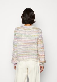 Maglione lavorato a maglia multicolore con motivo testurizzato, caratterizzato da strisce pastello e un colletto a coste. Maniche lunghe con polsini arricciati.
