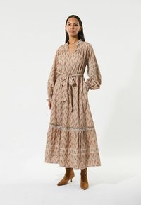 Abito lungo di colore beige chiaro con un motivo a foglie in rosa e marrone. Presenta un colletto, maniche lunghe e una cintura abbinata. Tessuto testurizzato.