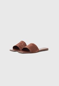 Brune semskede slip-on sandaler med åpen tå-design og flat lærsåle. Har en glatt tekstur og rundede øvre kanter.