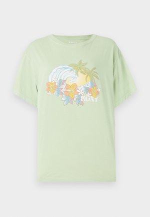 T-shirt manches courtes vert clair avec un graphique de vague et de fleur, portant le nom de la marque "ROXY" en blanc. Matériau en coton doux.