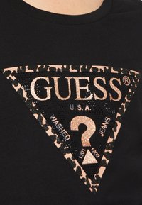 Schwarzes T-Shirt mit einem dreieckigen Logo, das mit einem Leopardenmuster verziert ist, und strukturiertem, glitzerndem Schriftzug in Roségold und Schwarz.