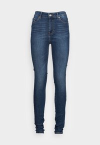 Jeans ajustados en denim azul oscuro. Diseño de cintura alta con una textura suave, estilo clásico de cinco bolsillos y detalles en hardware plateado.