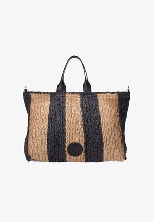 Bolso grande de mano tejido con franjas verticales anchas alternadas en negro y paja natural, y parche redondo con logo negro en el centro inferior.