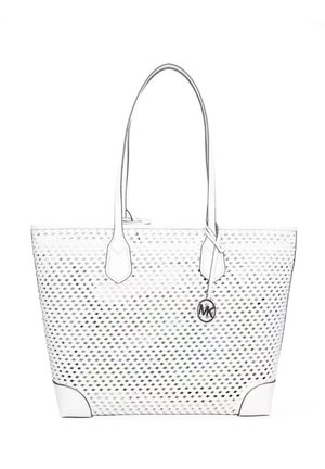 Sac fourre-tout blanc avec une texture à motifs losange, longues anses et un pendentif métallique rond suspendu à une anse.