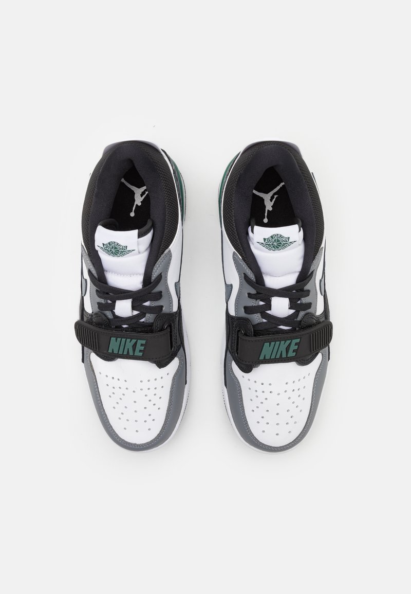 Baskets Nike avec une palette de couleurs blanc et gris, accents noirs, tige perforée et une sangle avec le texte "NIKE". Logo Jordan visible.