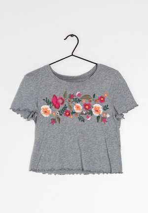 T-shirt grigio a maniche corte con scollatura rotonda e maniche arricciate. Caratterizzato da un vivace ricamo floreale nei colori rosa, arancio e verde.