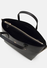 Zwarte leren tote bag met dubbele handvatten, gouden rits en een patroon aan de binnenkant. Heeft een open top ontwerp en een subtiele merkl logo.