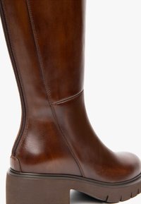 Braune Lederstiefel bis zum Knie mit glatter Oberfläche, seitlichem Reißverschluss und dicker Ferse. Leicht strukturierter Schaft, runde Zehenform, minimale Nähte.