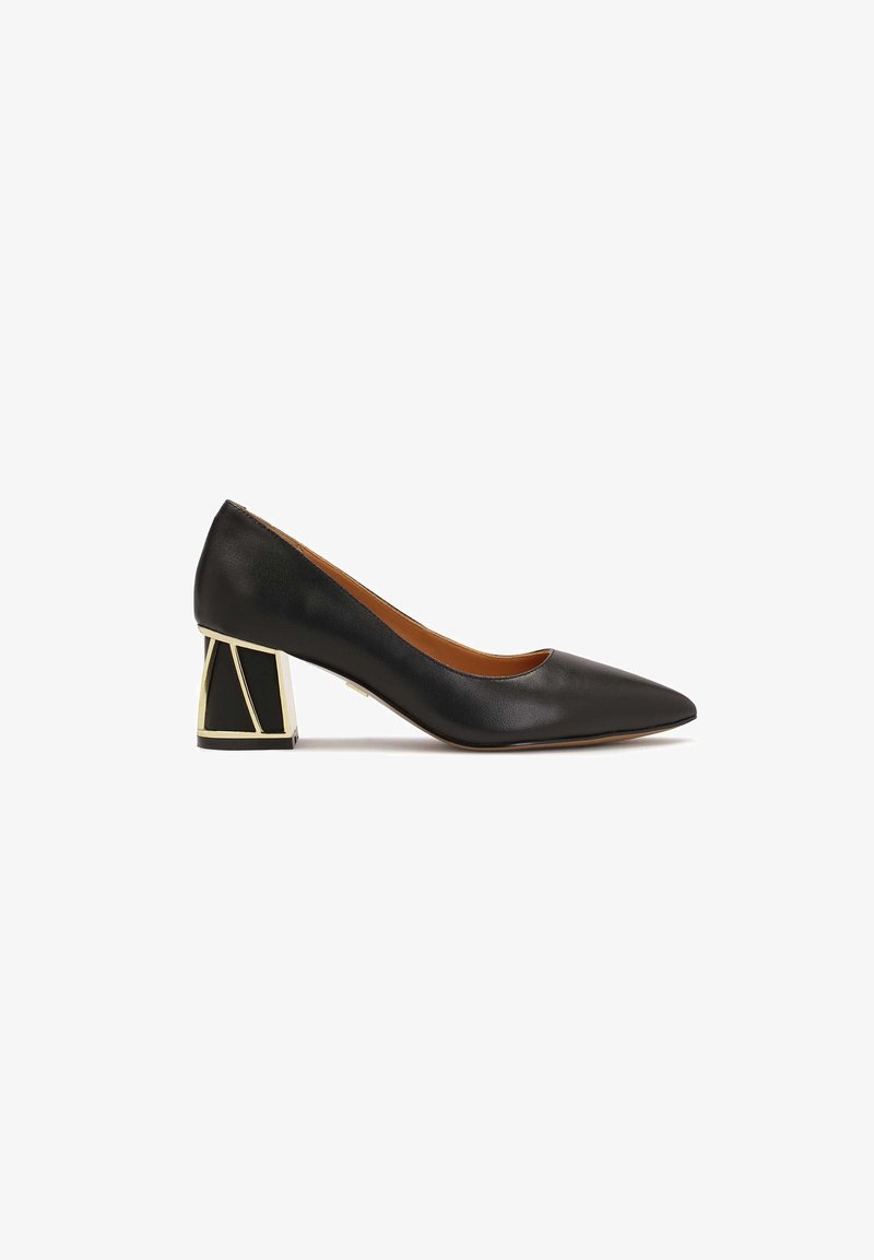 Escarpin en cuir noir à bout pointu avec un talon bloc géométrique orné d'accentuations en métal doré, présenté sur fond blanc.
