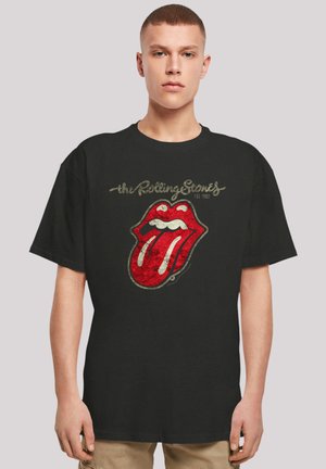 Black cotton t-shirt featuring a distressed red Rolling Stones logo with a protruding tongue, accented by gold lettering above and below the graphic.