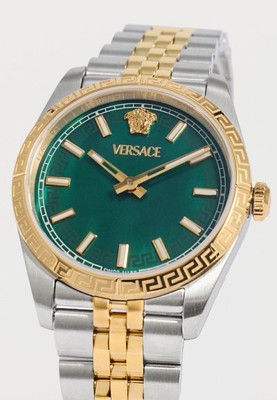 Ρολόι χειρός Versace με πράσινο καντράν, χρυσούς δείκτες ώρας και δείκτες, χρυσό λογότυπο Medusa στη θέση 12, χρυσό και ασημένιο μεταλλικό μπρασελέ.