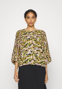 Blusa floral com mangas bufantes de 3/4, apresentando um padrão floral multicolorido sobre um fundo verde escuro. Tecido suave, design de ajuste solto.