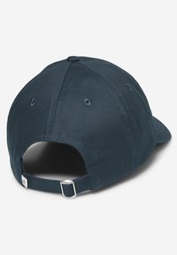 Navy blue cap with a curved brim, cotton fabric, rear adjustable strap, and metal buckle detail, featuring stitched ventilation holes.