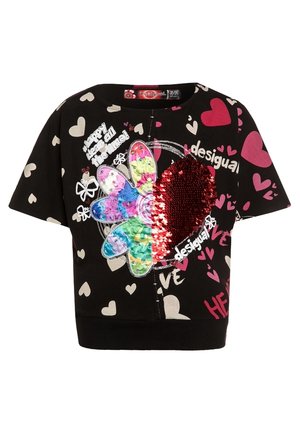Chemise noire à manches courtes avec des cœurs blancs et roses, un patch fleur coloré, un cœur rouge en sequins, et un texte blanc indiquant "desigual" et "happy days all the time".