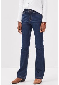 Tummansiniset leveälahkeiset farkut, jotka on valmistettu denimistä, ja niissä on muotoiltu vyötärö sekä lievää joustoa. Helma on viimeistelty näkyvillä saumatiedoilla.