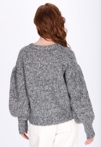 Grauer Strickpullover mit einer strukturierten, flauschigen Optik. Hat einen Rundhalsausschnitt, Puffärmel und gerippte Bündchen. Lockerer Schnitt.