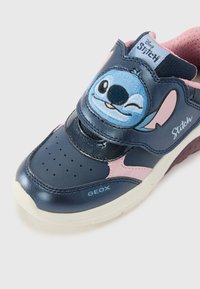 Navy blue leather sneaker with pink accents and a Velcro strap, featuring an embroidered Stitch character and perforated toe for breathability.